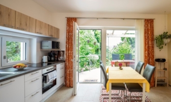 Wohnkche Apartment Panorama mit Blick ber die Terrasse in den Garten